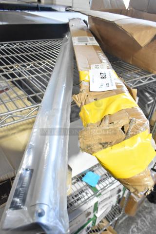 Two new San Jamar CK6544A 44" x 2" aluminum ticket holders, wall-mounted, marked “scratch and dent,” in packaging.