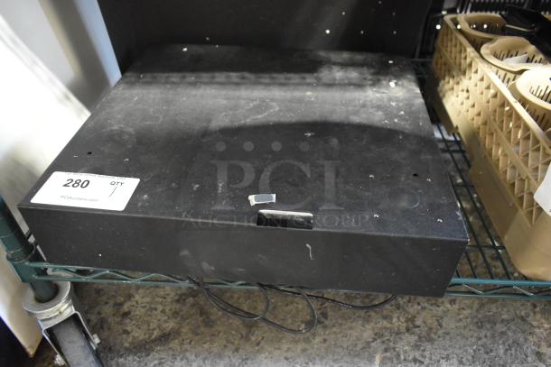 Micros Cash Drawer on shelf, black, used condition, visible scratches, auction tag with "280" and website link, cords attached.