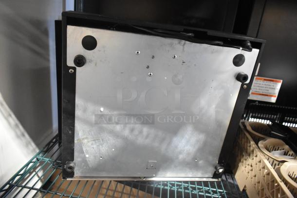 Micros Cash Drawer, metal construction, underside view, shows mounting points and wiring. Slight wear visible.