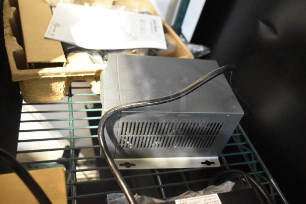 Assorted electronics including a power conditioner, Amino device, remote, and Symbol barcode scanner on a shelf.