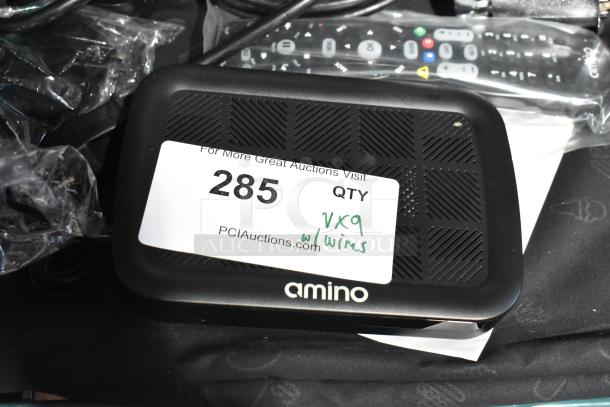 Alt text: "Lot of 9 items including Amino device with label tag '285,' remote, wires, and Symbol barcode scanner for auction."