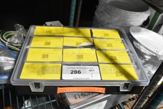 Plastic toolbox with yellow labeled compartments, filled with various tools. Label reads "286 QTY, PCIauctions.com."