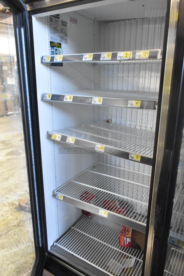 2019 True GDM-49F-HC commercial freezer with 2 glass doors, wire shelves, and pricing labels. Model and voltage info visible.