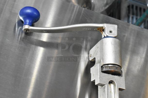 Edlund commercial can opener with blue handle, mounted on metal surface. Slight rust on joint, in used condition.