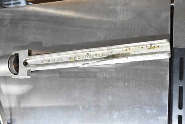 Edlund commercial can opener with visible branding; used condition with some surface rust and wear, Burlington, VT, USA marking.