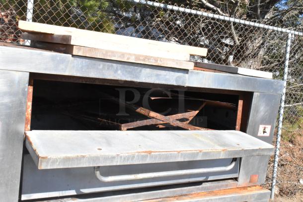 Attias 2 JS 6-18 gas-powered pizza oven, single deck, 200,000 BTU, visible wear, outdoors with protective coverings.