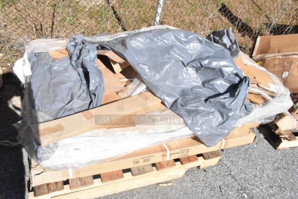 Plastic-wrapped pallet of six brand new scratch and dent items, including wire shelves. Packaging slightly damaged.