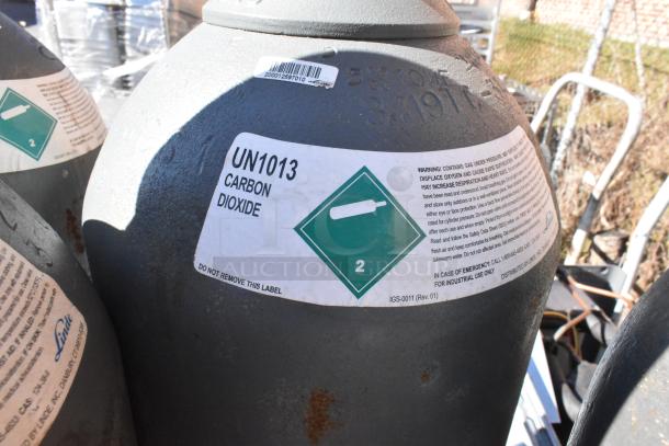 Seven carbon dioxide tanks labeled UN1013, with wear marks; pickup only.