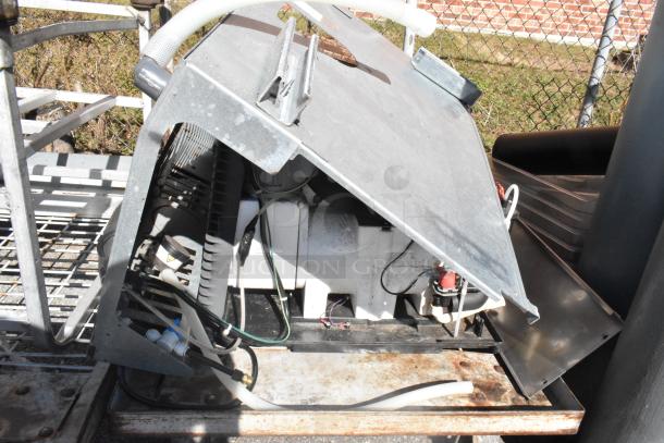 Commercial flat cart with industrial casters, carrying various mechanical components. Used condition, metallic frame.