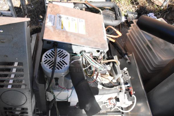 Commercial flat cart with casters, used condition, filled with assorted industrial components and bins, visible instruction label.