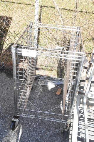 Chrome finish pan transport rack with commercial casters, multiple shelf slots, outdoor setting, tag labeled "315."