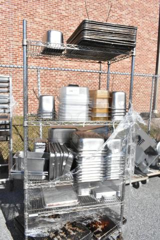 Chrome finish 4-tier wire shelving unit on commercial casters, includes stainless steel drop-in bins. Buyer must dismantle.