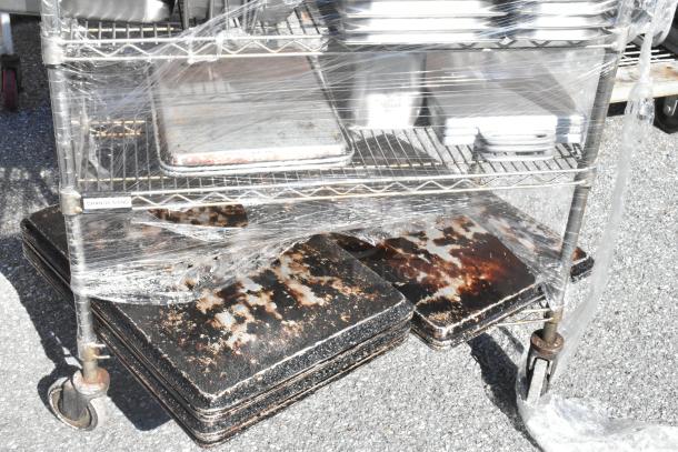Four-tier chrome wire shelving unit with commercial casters, featuring stainless steel drop-in bins. Needs dismantling by buyer.