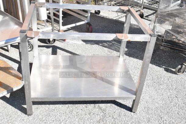 Two metal equipment stands, open-frame design, with visible wear and rust marks. Ideal for industrial use.