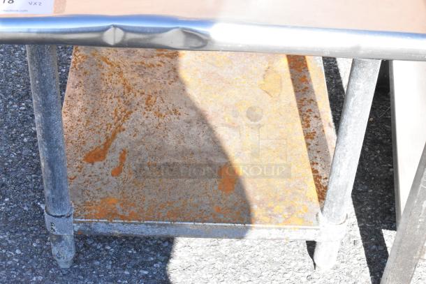 Two metal equipment stands with visible rust and wear on surfaces, showing sturdy construction and tubular legs.