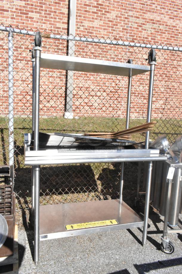 Commercial stainless steel table with under shelf and casters, suitable for kitchen use. Appears in good condition.