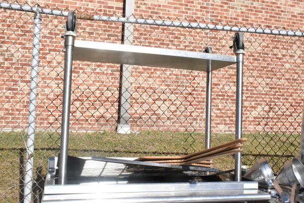 Stainless steel commercial table with under shelf and casters, in used condition. Ideal for restaurant kitchens.