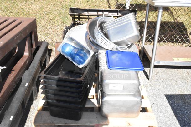 Pallet lot with various poly and stainless steel drop-in bins, colanders, and blue-lidded containers, in used condition.