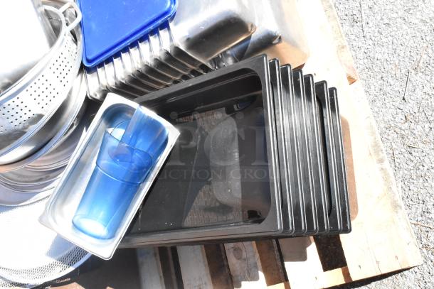 Pallet with various kitchen items including poly drop-in bins, colanders, and stainless steel bins in used condition.