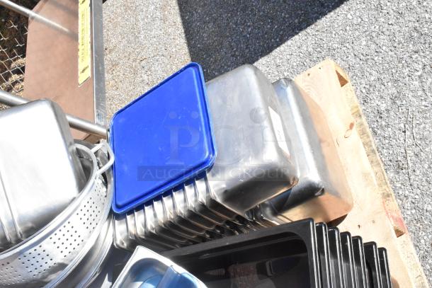 Pallet lot of assorted items including stainless steel and poly drop-in bins, colanders, and more, visible on wooden pallet.