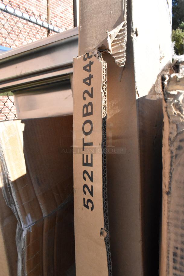 Damaged cardboard packaging of new items, marked "522ETOB2448," energy-efficient folding chairs and sink inside.