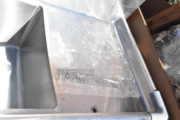 Commercial 3 bay sink with dual drain boards, stainless steel construction, visible wear, label with "CASC" marked.