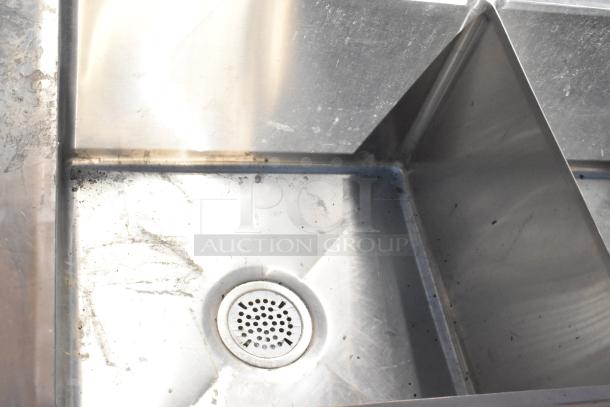 Commercial 3 bay sink with dual drain boards, stainless steel, visible wear and dirt, ideal for high-volume kitchens.