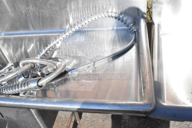 Commercial 3 bay sink with dual drain boards and coiled spray hose. Stainless steel, suitable for heavy-duty use. Excellent condition.