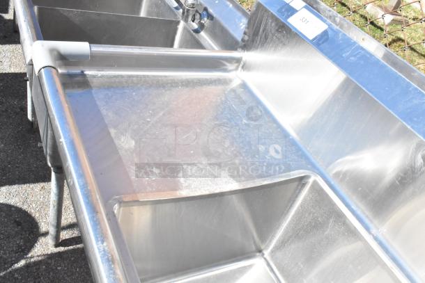 Commercial 3 bay stainless steel sink with dual drain boards, used condition, label reading "331".