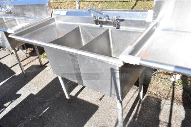 Commercial 2-bay stainless steel sink with left side drain boards, faucet, sturdy build, used condition.