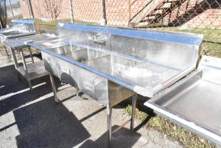 Commercial 3-bay sink with dual drain boards and faucet; stainless steel, labeled rinse and sanitize, outdoor setup.