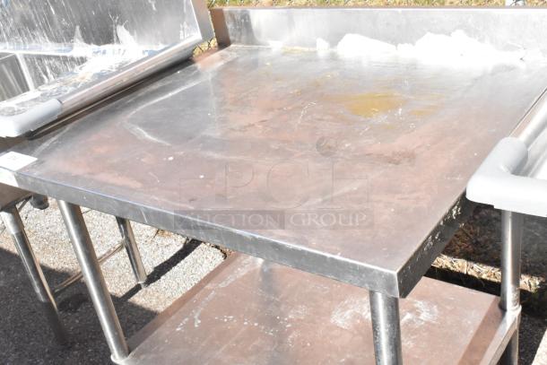 Regency 600TSB3036S commercial table with under shelf, stainless steel, shows surface wear, ideal for kitchen use.