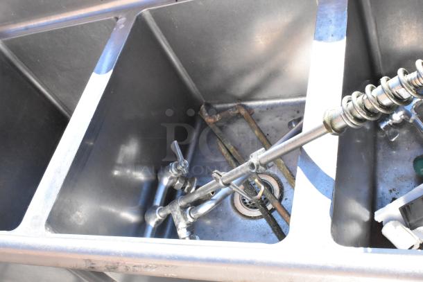 Commercial 3 bay sink with left side drain board, stainless steel construction, visible fittings, and signs of use.