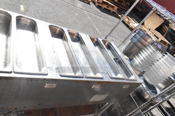 Commercial 4 bay steam table with under shelf, stainless steel, used condition, slight rust visible, ideal for food service.