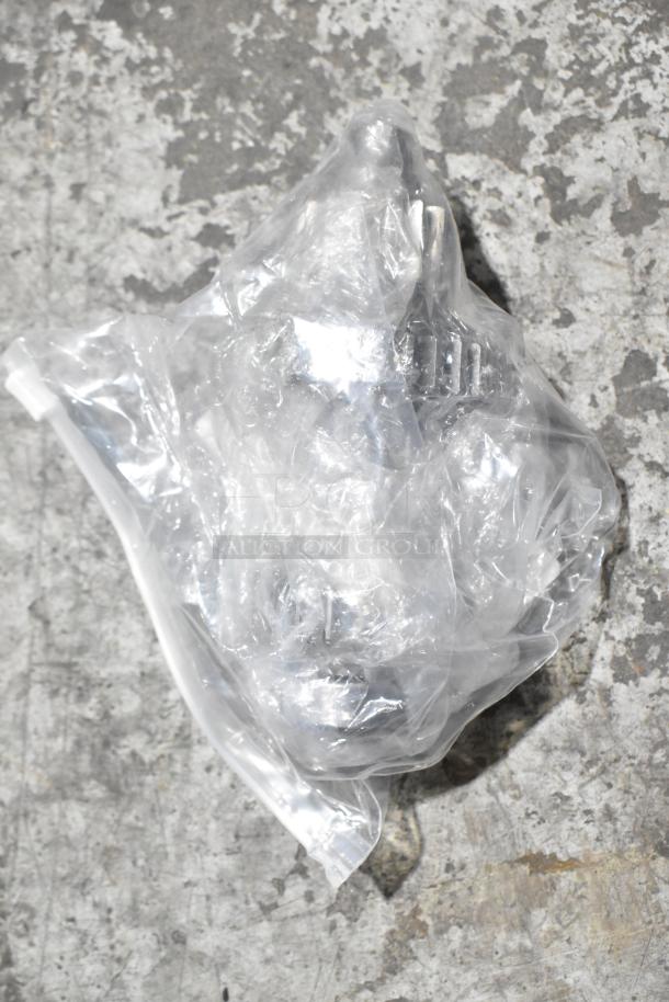 Clear plastic-wrapped item, labeled "BRAND NEW SCRATCH AND DENT" on a concrete floor, showing its condition and packaging.