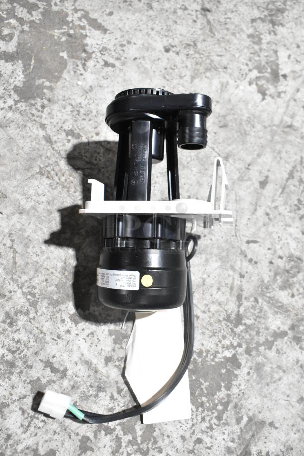 Brand new mechanical part with minor scratches; black plastic, features a label with specifications; attached wiring.