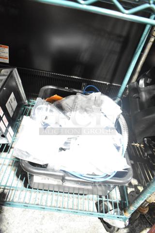 Lot of various items including Flojet 20578007C hardware, cords in plastic containers on a metal rack. Mixed condition.