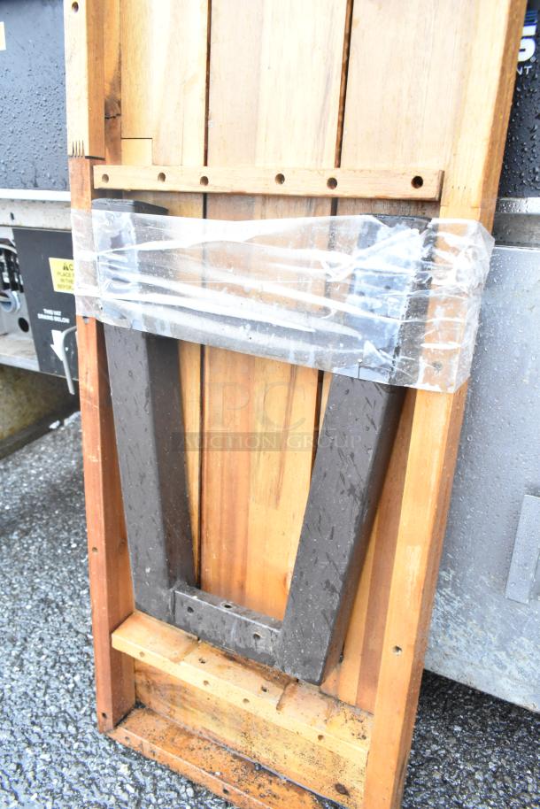 Wooden butcher block tabletop with sturdy legs, shown folded and wrapped in plastic, featuring natural wood grain.