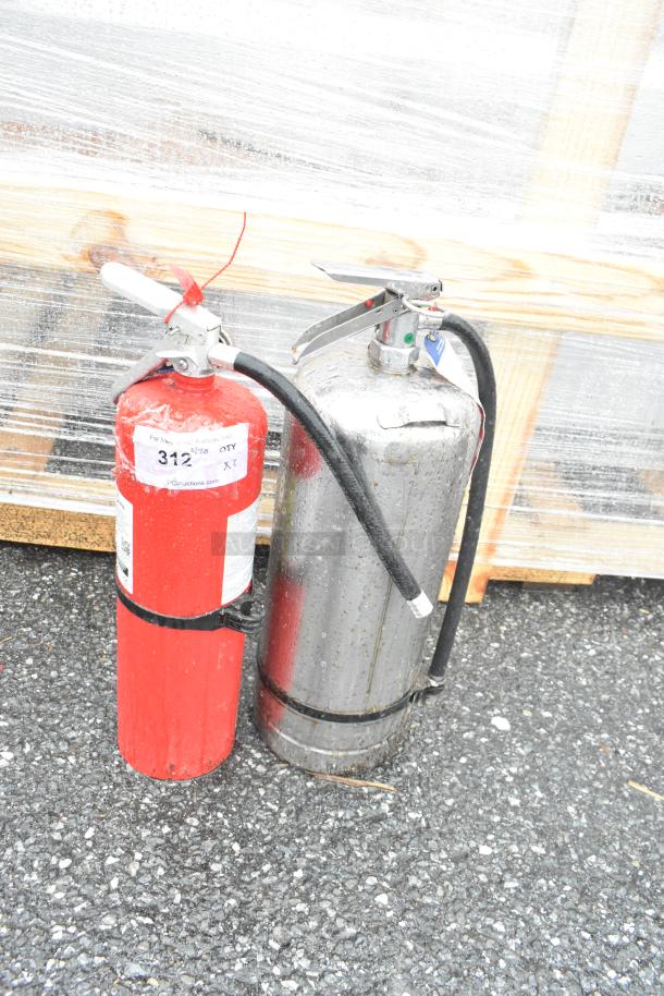 Two fire extinguishers, one red and one silver. The red extinguisher shows a label with "312" written on it. Buyer pickup only.