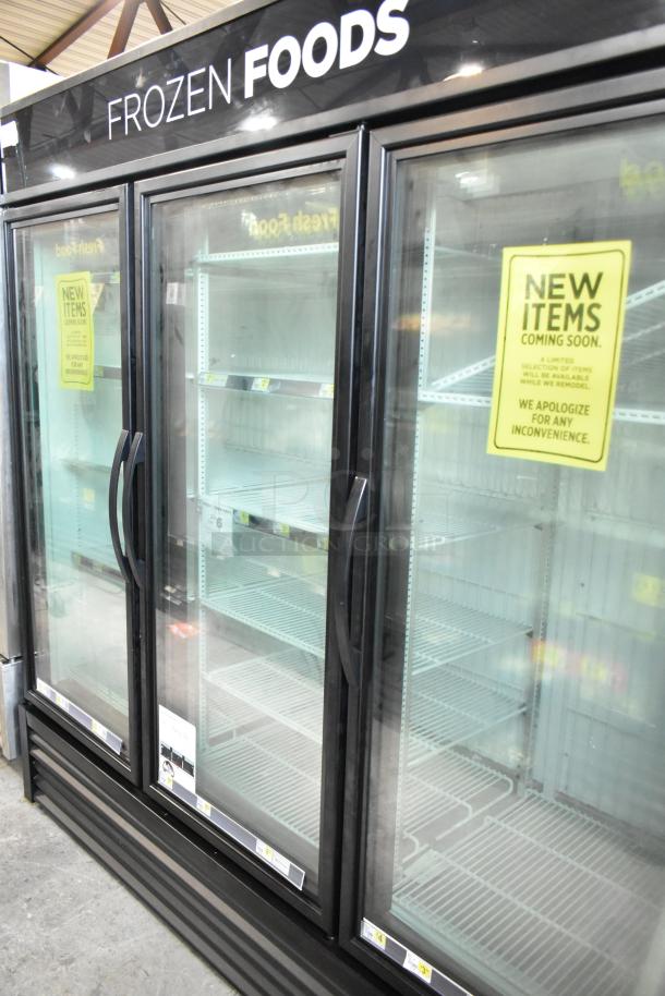 2025 True GDM-72F-HC commercial freezer merchandiser, 3 glass doors, black frame, "Frozen Foods" sign, tested working condition.