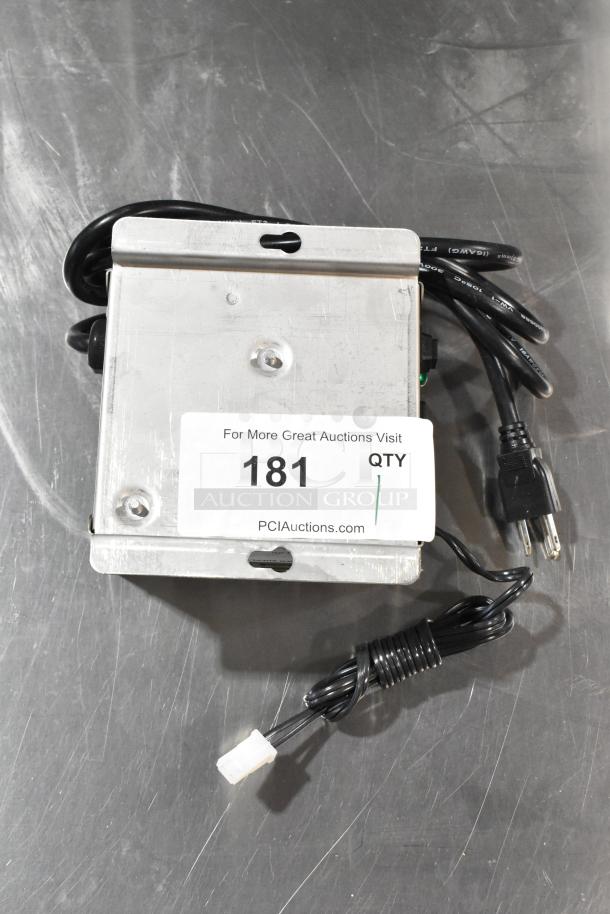 Lancer power supply with attached cables and a metal casing. Auction label 181. Good condition.