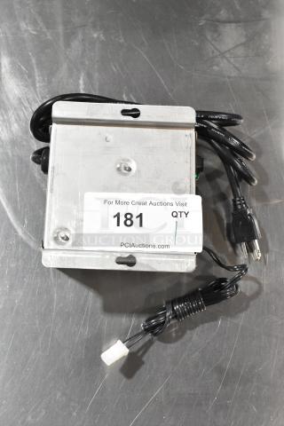 Lancer power supply with attached cables and a metal casing. Auction label 181. Good condition.