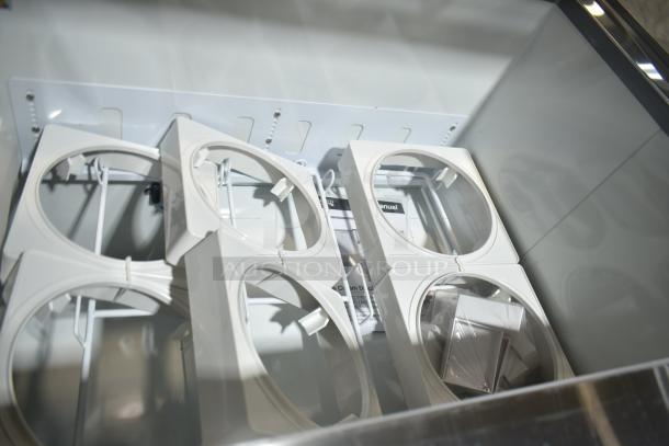 Brand new Avantco 178CPW68HC ice cream dipping cabinet interior, showing 12 white tub holders. Manual and accessories visible.