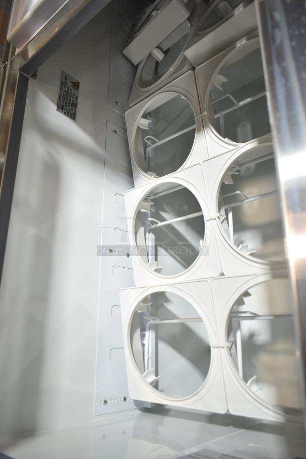 Brand new Avantco 178CPW68HC 12-tub ice cream dipping cabinet interior, showing white tub holders and stainless steel elements.