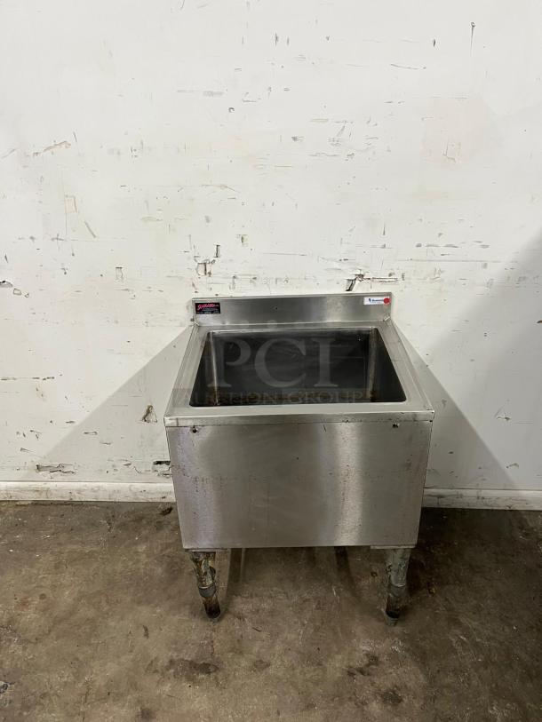 24-inch stainless steel cold plate ice bin with drain by COLD PLATE. Features visible wear and rust on legs.