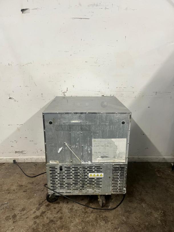 TRAULSEN UHT27-L 27" undercounter refrigerator, left-hinged door, visible wear, tags detailing safety warnings.