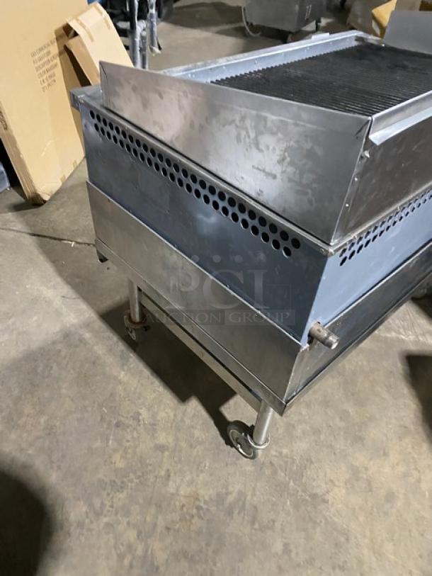 Bakers Pride stainless steel gas char broiler with back and side splash, undershelf stand, and casters. Good condition.