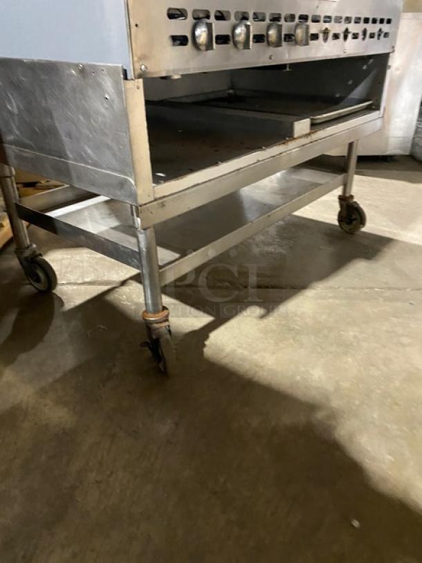 Bakers Pride stainless steel gas char broiler with radiant burners, back and side splash, undershelf cart on casters.