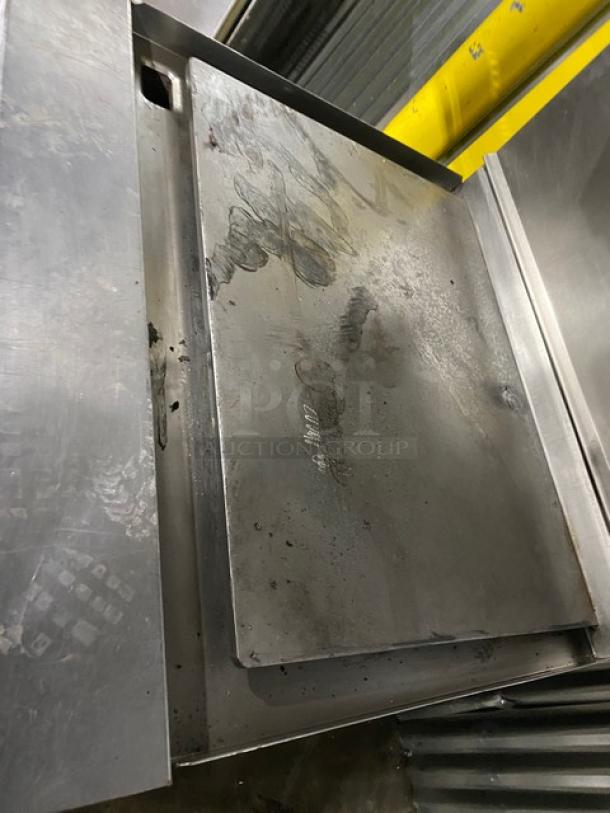 Jade Range stainless steel gas-powered oven with plancha top, backsplash, and salamander broiler; features visible wear.