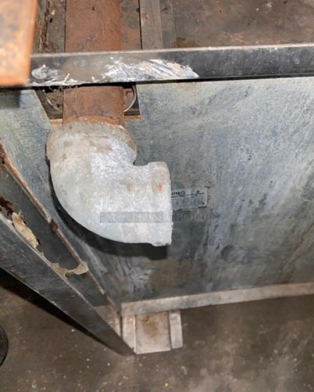 Jade Range gas-powered commercial cooking range, featuring a stainless steel build, flat griddle, backsplash, and overhead broiler.